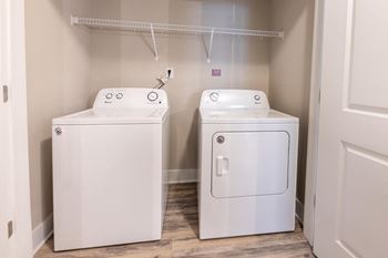 A white washing machine and dryer in a small laundry room.
